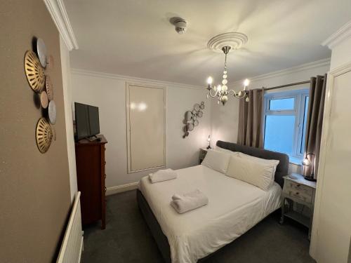 伊斯特布恩亚特兰大旅馆的卧室配有白色的床和吊灯。