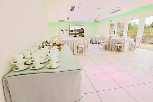 Upper ArleyThe Grange的一间设有白色桌子和白色杯子及椅子的房间