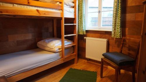 梅斯多夫Hütte mit Herz im Harz的客房设有双层床、椅子和窗户。