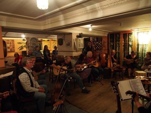 Dundonnell杜朵纳尔酒店的一群坐在房间里演奏乐器的人