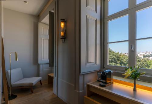 里斯本维莱德帕拉西奥圣卡塔琳娜州酒店的客房设有窗户、书桌和椅子