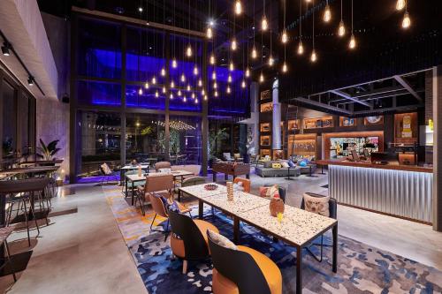 台中市Moxy Taichung的一间带桌椅的餐厅和一间酒吧