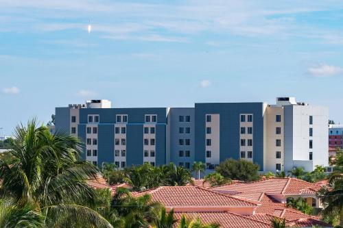 卡纳维拉尔角SpringHill Suites by Marriott Cape Canaveral Cocoa Beach的一座大型蓝色建筑,前面有棕榈树