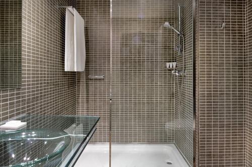 阿尔赫西拉斯AC Hotel Algeciras by Marriott的带淋浴和玻璃浴缸的浴室