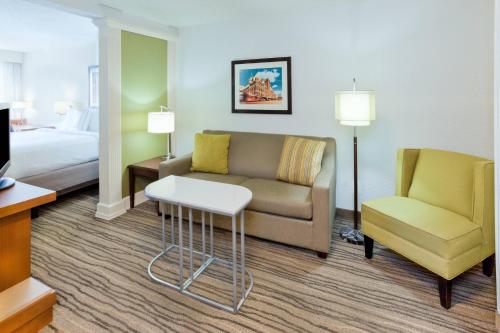 圣路易斯帕克明尼阿波利斯西部圣路易斯公园春季山丘套房酒店的酒店客房配有沙发、椅子和床