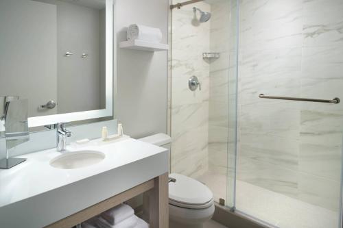 迈阿密迈阿密椰林万怡酒店的浴室配有卫生间、盥洗盆和淋浴。