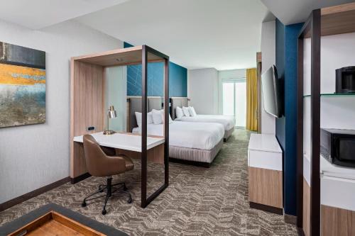 格林维尔SpringHill Suites by Marriott Greenville Downtown的酒店客房配有两张床和一张书桌