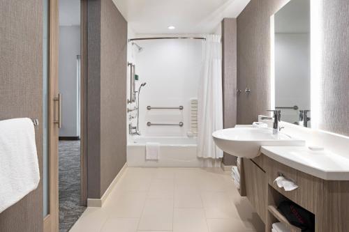 格林维尔SpringHill Suites by Marriott Greenville Downtown的带浴缸、水槽和淋浴的浴室