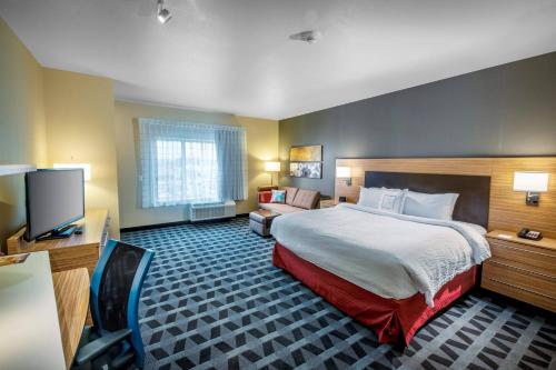 俄勒冈州TownePlace Suites by Marriott Toledo Oregon的酒店客房,配有床和电视