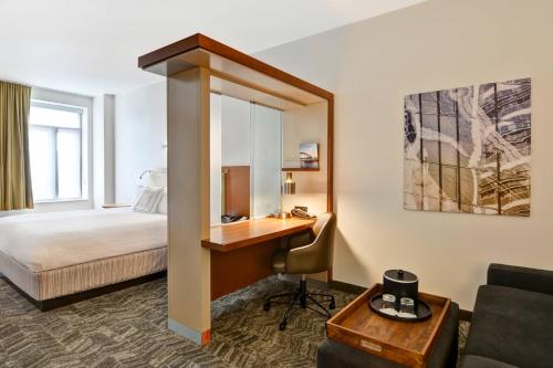 辛辛那提马里奥特辛辛那提市中心春季山丘套房的酒店客房配有书桌和床。