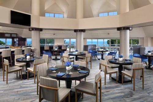 丹纳岬拉古娜崖万豪度假酒店及Spa的一间带桌椅的餐厅和一间酒吧