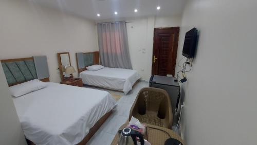 开罗Ramses Guest House的酒店客房设有两张床和电视。