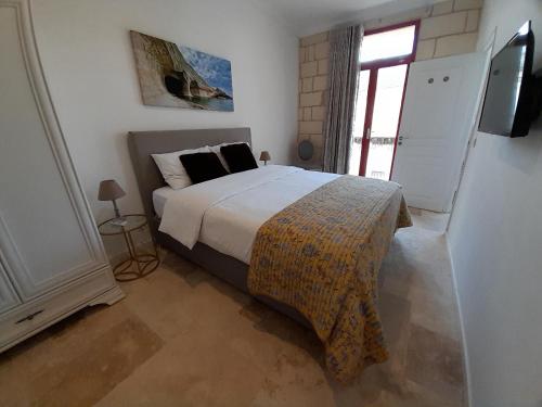 ŻabbarPalazzo Pisani Malta B&B的一间卧室设有一张大床和一个窗户。