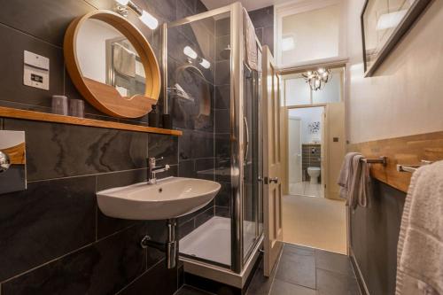 巴斯Bath View Apartments的一间带水槽、淋浴和镜子的浴室