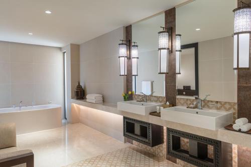 亚喀巴Al Manara, a Luxury Collection Hotel, Aqaba的一间带两个盥洗盆和壁炉的浴室