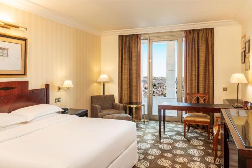 安曼Sheraton Amman Al Nabil Hotel的配有一张床和一张书桌的酒店客房