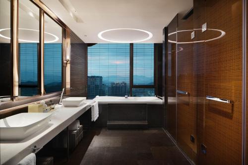 云浮云浮新兴筠城喜来登酒店的一间带两个盥洗盆和一个带窗户的浴缸的浴室