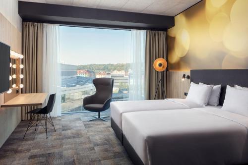 布拉格STAGES HOTEL Prague, a Tribute Portfolio Hotel的酒店客房设有两张床、一张书桌和一个窗户。