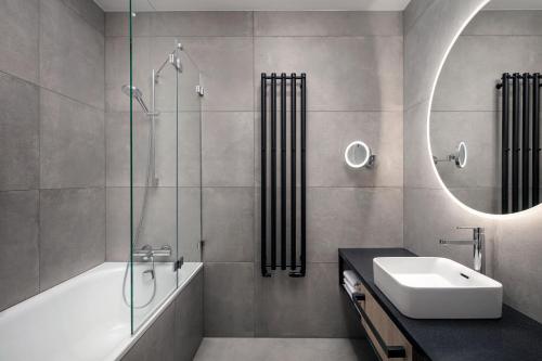 布拉格STAGES HOTEL Prague, a Tribute Portfolio Hotel的带浴缸、水槽和镜子的浴室