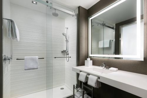 帕克城AC Hotel Park City的带淋浴、盥洗盆和镜子的浴室