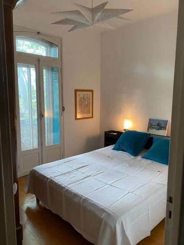 蒙彼利埃Villa avec piscine en plein cœur de ville的卧室配有带蓝色枕头的大型白色床