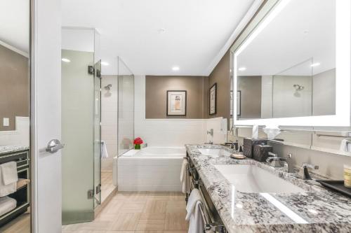 华盛顿麦迪逊希尔顿酒店的一间带两个盥洗盆和大镜子的浴室