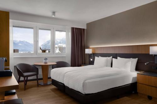 因斯布鲁克因斯布鲁克万豪AC酒店 的配有一张床、一张桌子和一张桌子的酒店客房