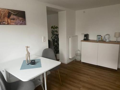 卡塞尔Klein aber oho! Neues Apartment in Stadt- und Fuldanähe的一间带白色桌子的客厅和一间厨房