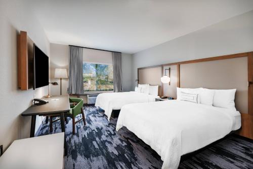 卡图萨Fairfield Inn & Suites by Marriott Tulsa Catoosa的酒店客房配有两张床和一张书桌