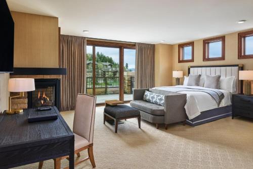 帕克城瑞吉鹿谷酒店的一间卧室配有一张床、一张桌子和一个壁炉