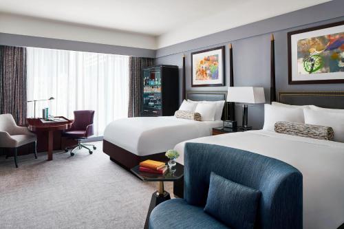 夏洛特夏洛特丽思卡尔顿酒店的酒店客房配有两张床和一张书桌