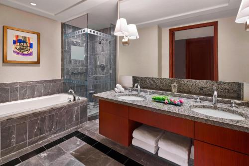 夏洛特夏洛特丽思卡尔顿酒店的浴室配有2个盥洗盆、浴缸和淋浴。