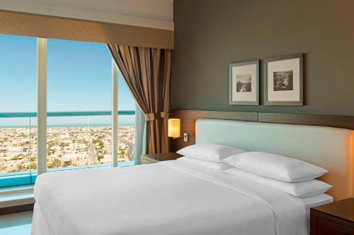 迪拜福朋喜来登扎耶德路酒店的一间卧室设有一张大床和大窗户