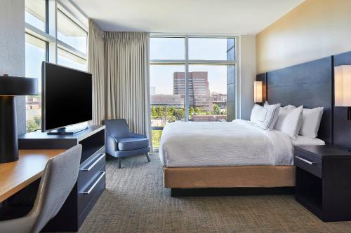 克利夫兰Residence Inn by Marriott Cleveland University Circle/Medical Center的酒店客房配有一张床和一张书桌及一台电视