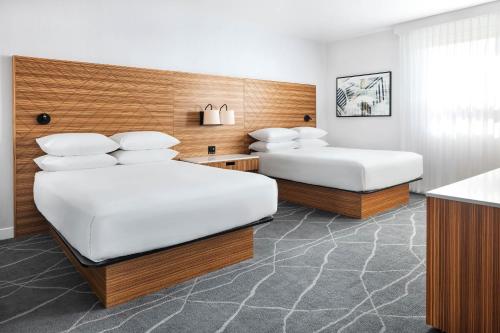 大草原城Delta Hotels by Marriott Grande Prairie Airport的酒店客房设有两张床和柜台。