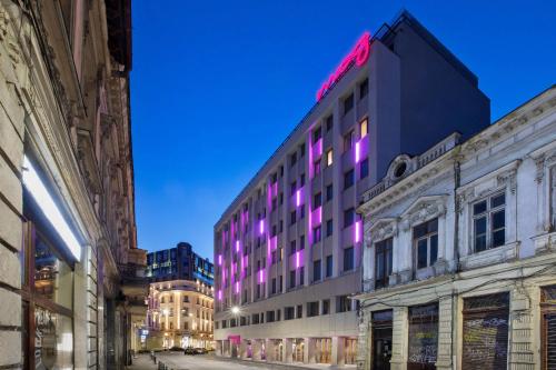 布加勒斯特Moxy Bucharest Old Town的建筑的侧面有紫色的灯