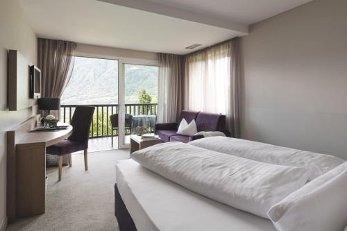 蒂鲁罗Boutiquehotel Minigolf的酒店客房设有一张床和一个阳台。