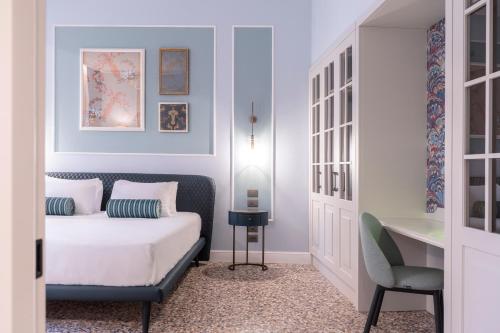 威尼斯Be Mate Ponte di Rialto的一间卧室配有一张床、一张桌子和一把椅子