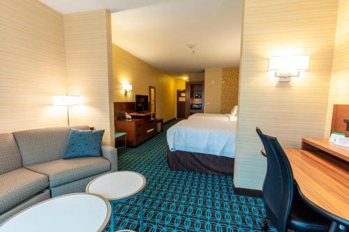 伍德斯托克Fairfield Inn & Suites by Marriott Atlanta Woodstock的酒店客房,配有床和沙发