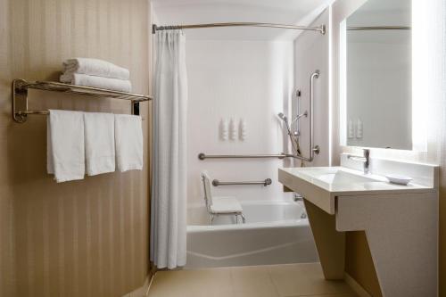 科罗拉多斯普林斯科罗拉多斯普林斯南万豪春季山丘套房酒店的白色的浴室设有浴缸和水槽。