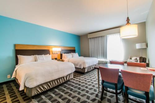 NewburghTownePlace Suites by Marriott Evansville Newburgh的酒店客房带两张床和一张桌子以及椅子。