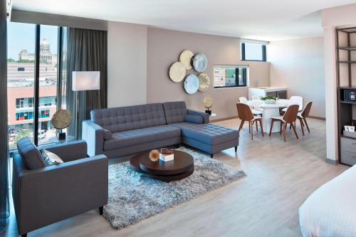 德梅因AC Hotel by Marriott Des Moines East Village的客厅配有蓝色的沙发和桌子