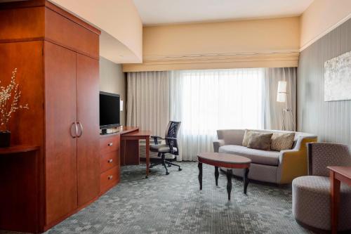 哥伦比亚哥伦比亚万怡酒店的一间配有沙发、一张桌子和一台电视的酒店客房