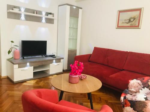 赫瓦尔赫瓦尔安娜公寓的客厅配有红色的沙发和桌子