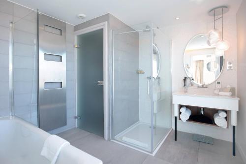 普罗旺斯艾克斯普罗旺斯艾克斯万丽酒店的一间带玻璃淋浴和水槽的浴室