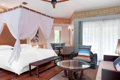 布拉伊新喀里多尼亚喜来登德瓦Spa及高尔夫度假酒店的酒店客房配有一张床铺和一张桌子。
