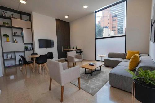 波哥大Acogedor loft en Centro Internacional de Bogotá的客厅配有沙发和桌子