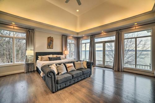 CadizSpacious Lakefront Kentucky Home Rental!的一间卧室配有一张床、一张沙发和窗户。