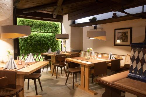 魏登斯塔德特库鲁格酒店的餐厅设有木桌和椅子,拥有绿色的墙壁