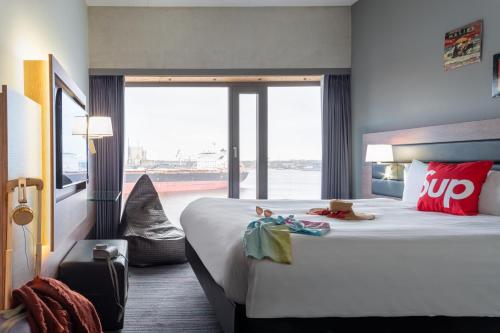 阿姆斯特丹Moxy Amsterdam Houthavens的酒店客房设有一张大床和大窗户
